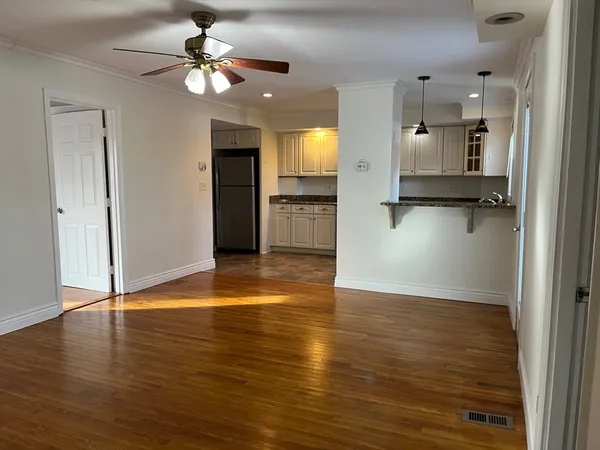 wooden floor in an empty room with a kitchen