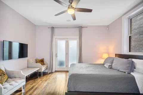 a bedroom with a bed and wooden floor