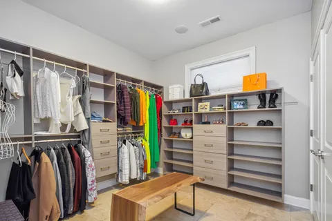 a view of walk in closet with clothes and shoes