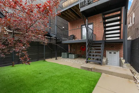 a view of a chair and table in backyard of the house