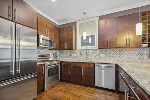 a kitchen with stainless steel appliances granite countertop a sink stove and refrigerator
