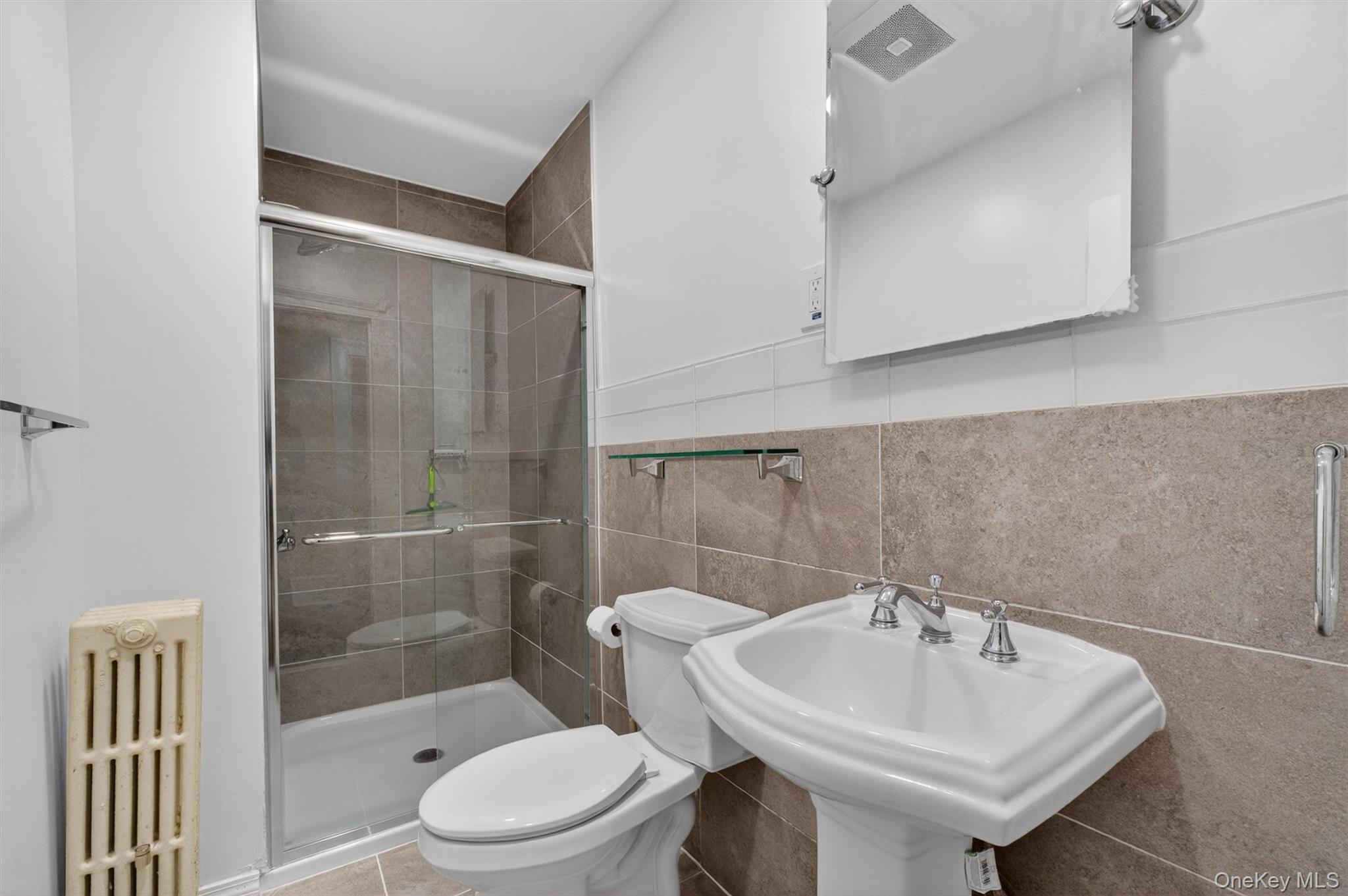 121 Old Glenham Road Fishkill, NY 12524 - Photo 14 of 50 Bathroom featuring a glass-enclosed shower, pedestal sink with chrome fixtures, tiled walls, and a recessed medicine cabinet mirror.
