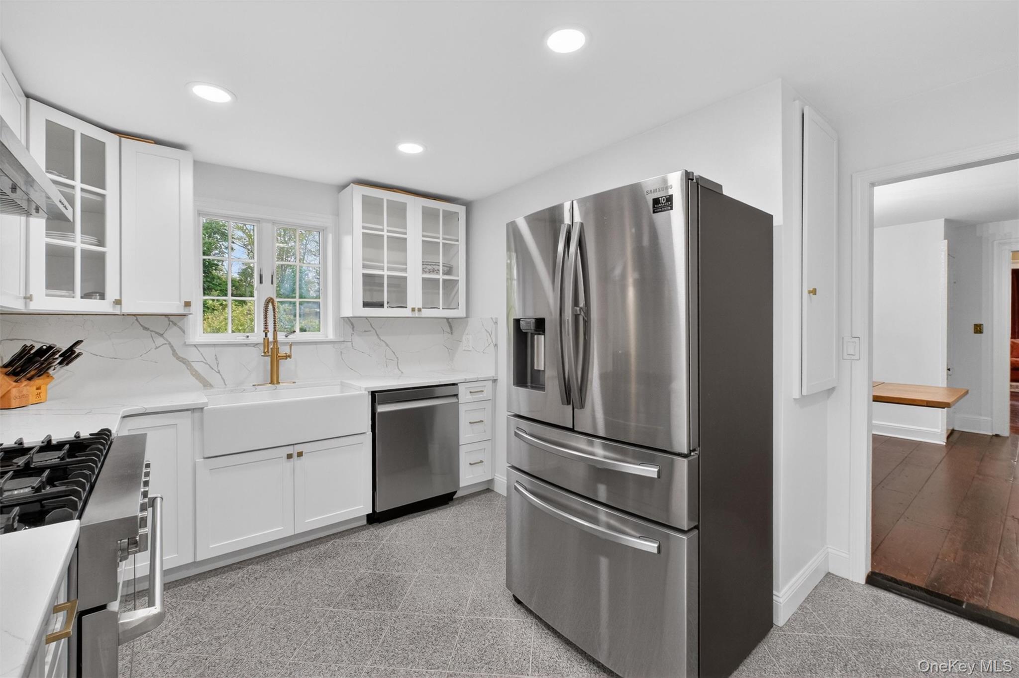 121 Old Glenham Road Fishkill, NY 12524 - Photo 19 of 50 Bright kitchen featuring white cabinetry, white quartz countertops with veining, a stainless-steel range with hood, a white farmhouse sink, recessed lighting and gold ornamentation hardware