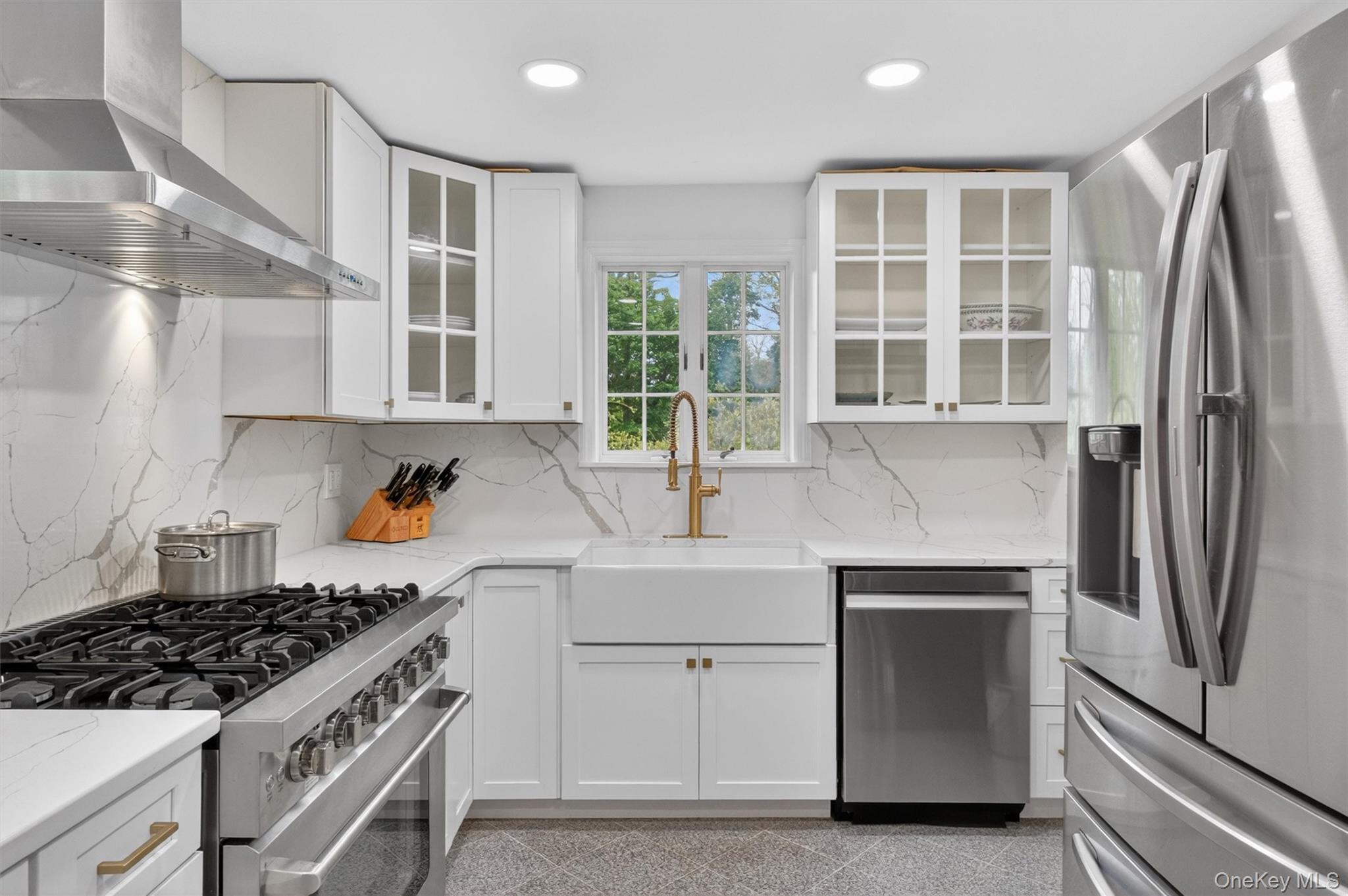 121 Old Glenham Road Fishkill, NY 12524 - Photo 20 of 50 Bright kitchen featuring white cabinetry, white quartz countertops with veining, a stainless-steel range with hood, a white farmhouse sink, recessed lighting and gold ornamentation hardware