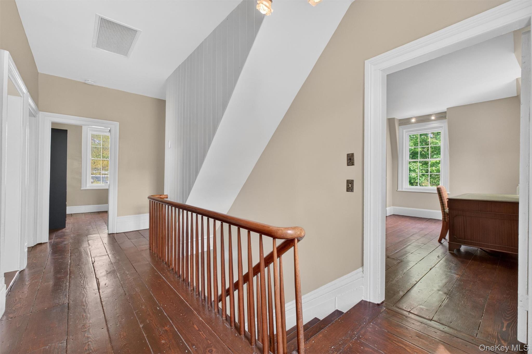 121 Old Glenham Road Fishkill, NY 12524 - Photo 22 of 50 Second-story hallway featuring rich hardwood flooring, a classic wooden balustrade, and doors leading to other living areas.