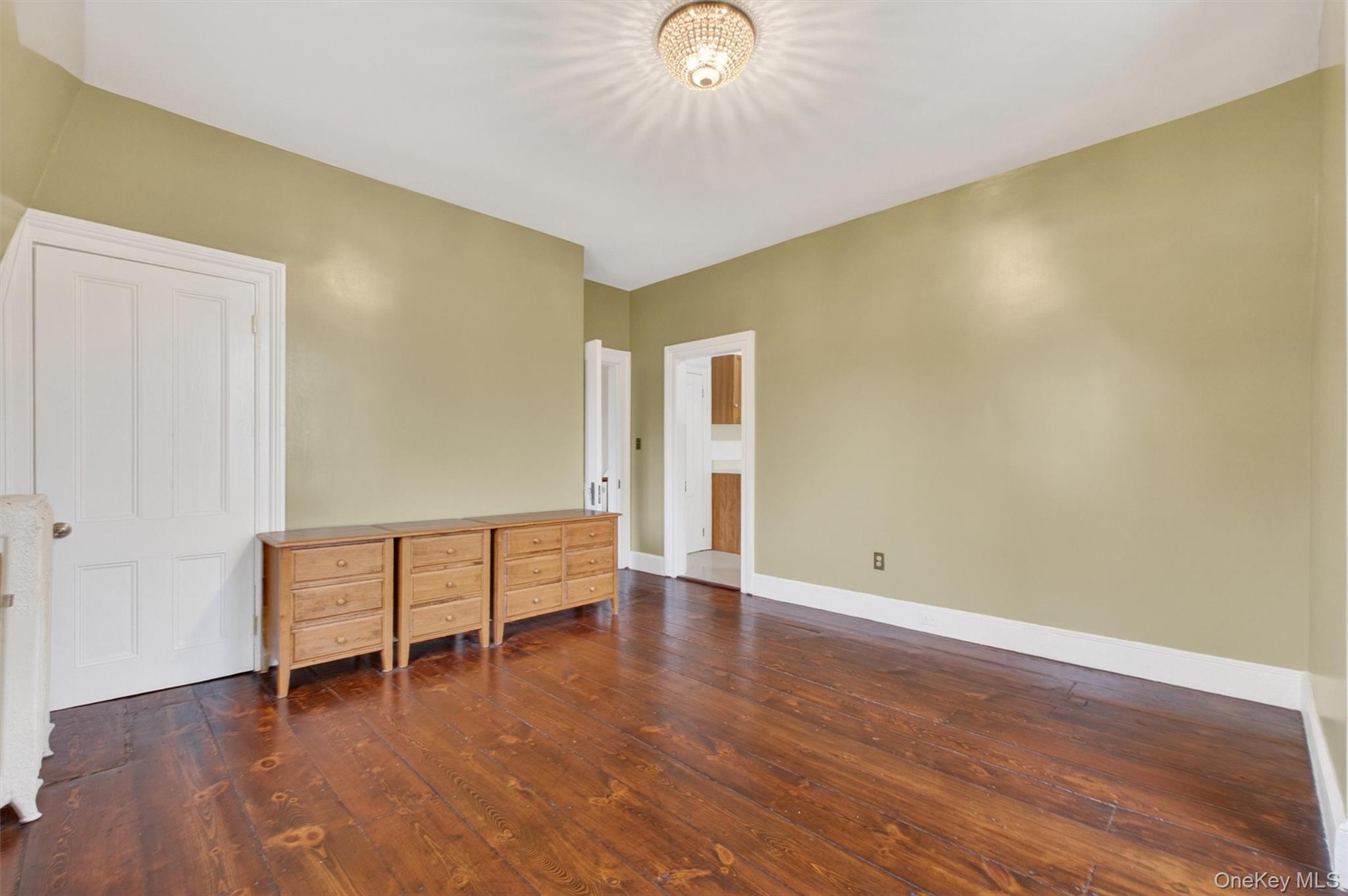 121 Old Glenham Road Fishkill, NY 12524 - Photo 29 of 50 Room featuring wide plank hardwood flooring, two large double-hung windows, and a ceiling-mounted light fixture.