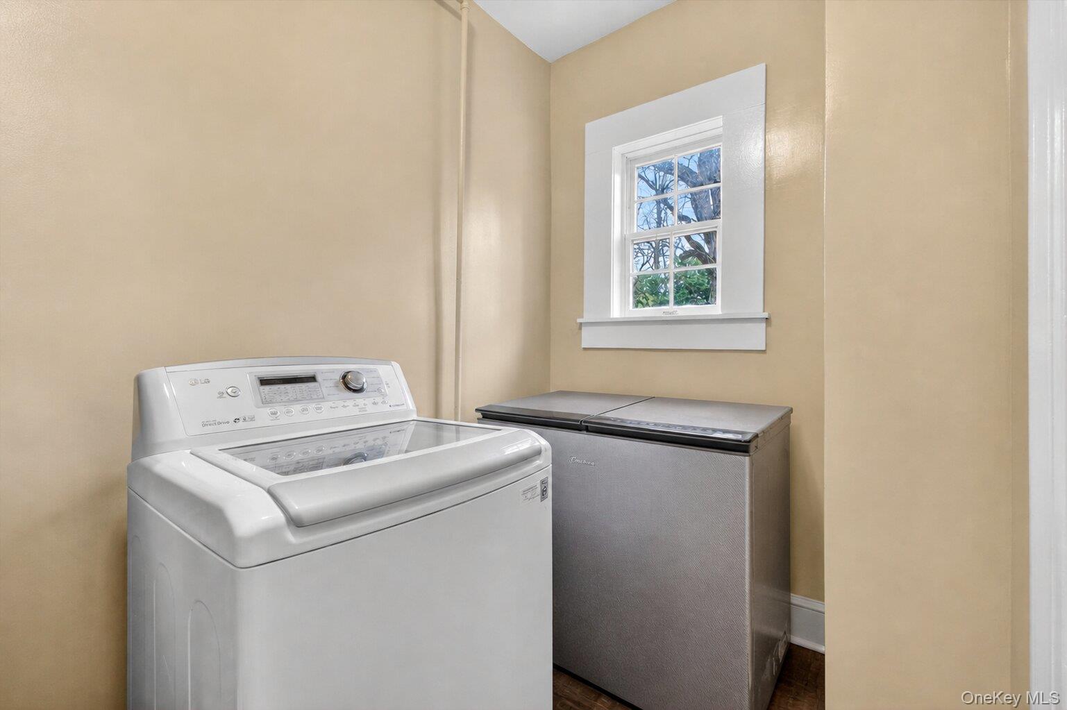 121 Old Glenham Road Fishkill, NY 12524 - Photo 36 of 50 Laundry area featuring a large window with white trim, tan painted walls, and hardwood flooring