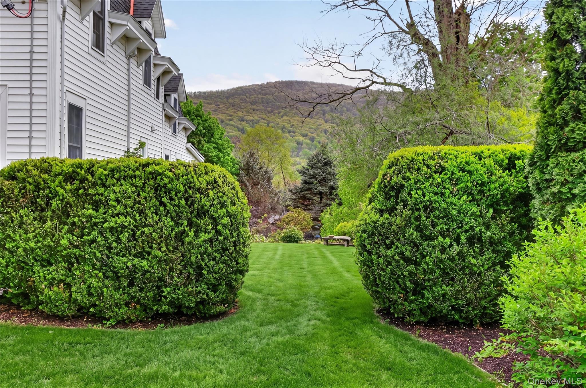 121 Old Glenham Road Fishkill, NY 12524 - Photo 43 of 50 Expansive green lawn framed by manicured hedges leading to the backyard with views of the hills and mountain.