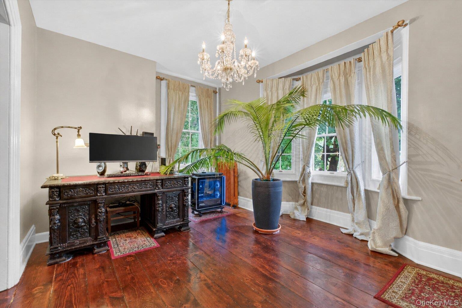 121 Old Glenham Road Fishkill, NY 12524 - Photo 10 of 50 Hardwood flooring extending through an arched doorway, featuring a crystal chandelier and large bay windows.