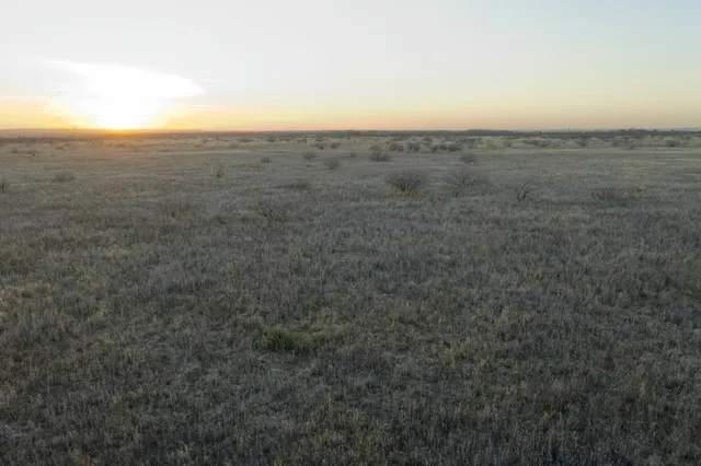 an aerial view of house with yard and mountain view in back