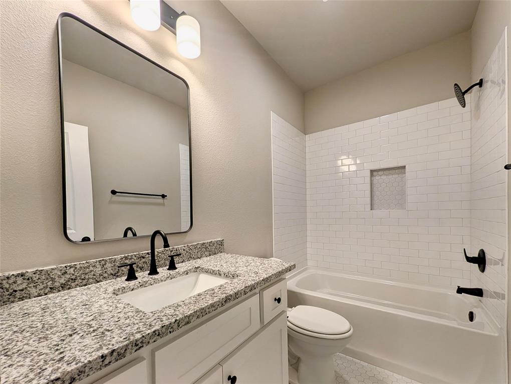 300 Rike Road Mabank, TX 75147 - Photo 14 of 18 a bathroom with a granite countertop sink a toilet and a mirror