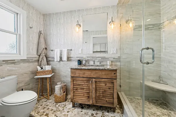 a bathroom with a sink a toilet and shower