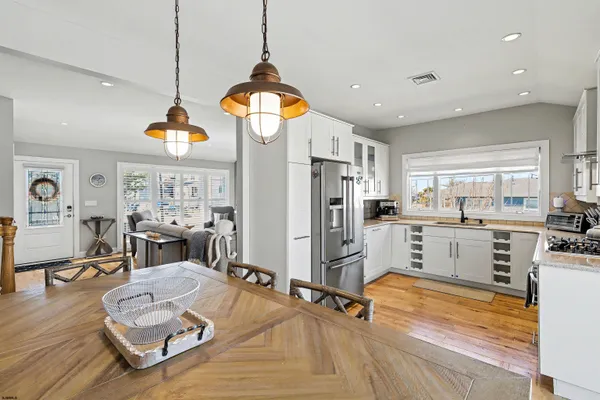 a room with stainless steel appliances kitchen island granite countertop furniture and a view of living room