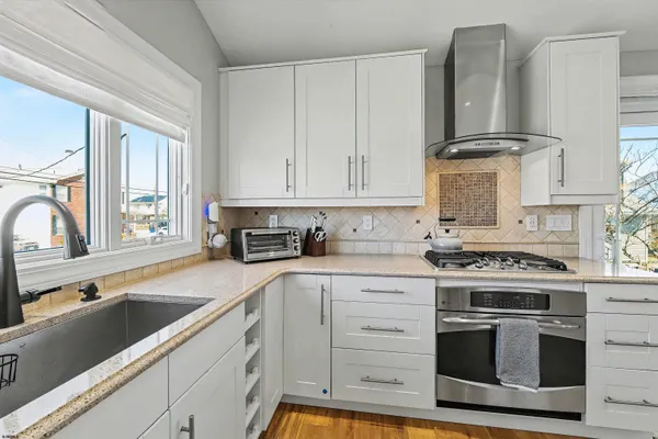 a kitchen with granite countertop white cabinets and appliances