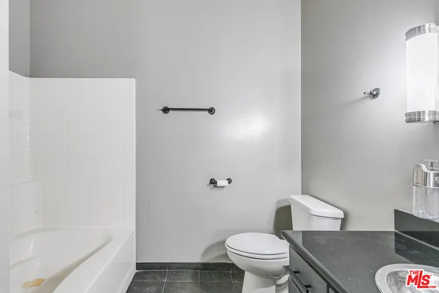 a white toilet sitting next to a bath tub