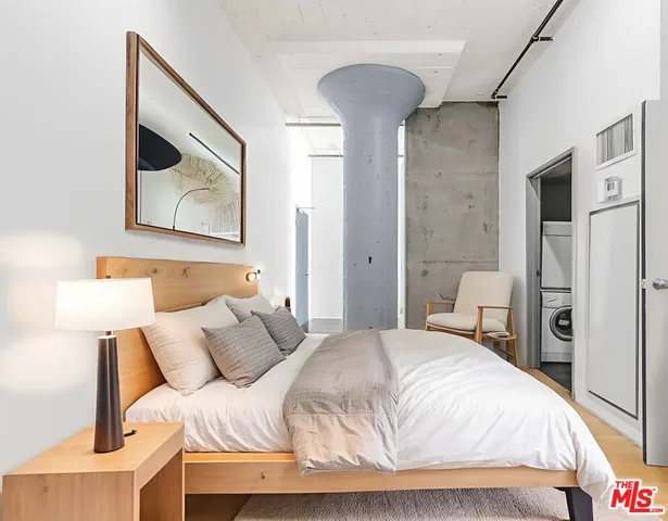 a bedroom with a bed and a painting on the wall