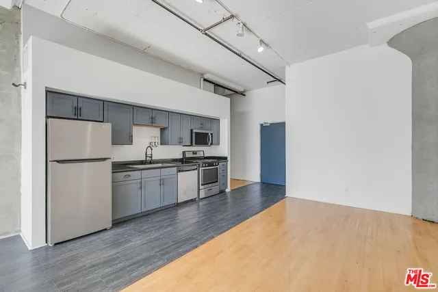 a kitchen with a refrigerator and a stove top oven