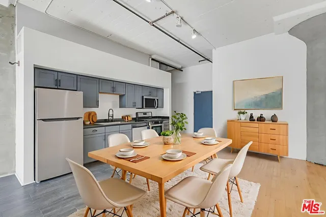 a dining room with stainless steel appliances kitchen island granite countertop a dining table and chairs