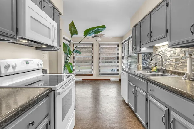a kitchen with stainless steel appliances granite countertop a sink a stove and cabinets