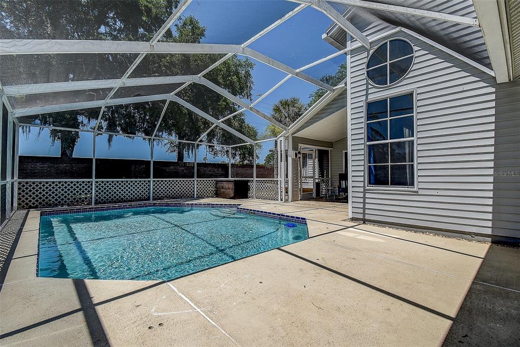 7730 Grimsby Lane New Port Richey, FL 34655 - Photo 17 of 48 a view of a backyard with table and chairs