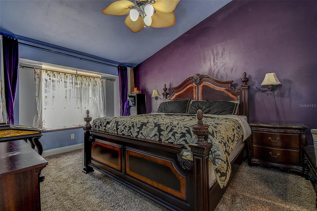 7730 Grimsby Lane New Port Richey, FL 34655 - Photo 36 of 48 a bedroom with a bed and a chandelier