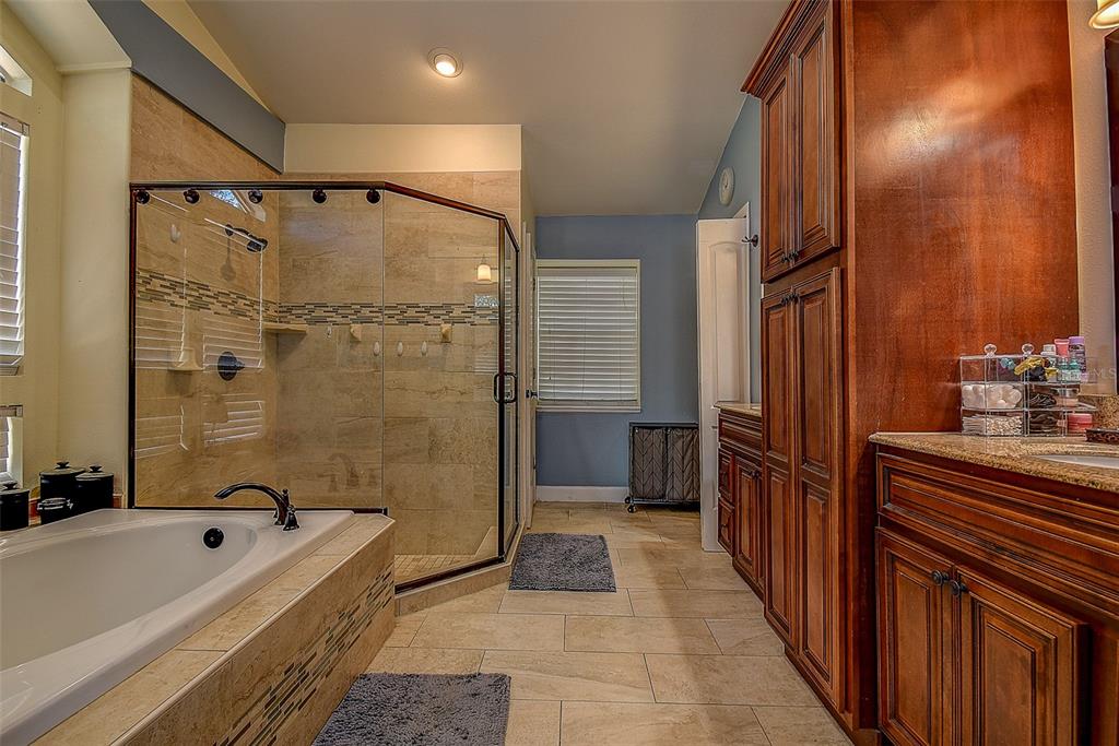 7730 Grimsby Lane New Port Richey, FL 34655 - Photo 44 of 48 a bathroom with a tub a sink a mirror and a shower