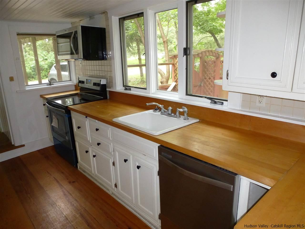 30 Peak Road Stone Ridge, NY 12484 - Photo 3 of 22 a kitchen with granite countertop a sink a stove and wooden floor