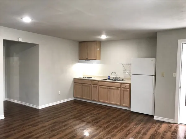 a kitchen with granite countertop white cabinets and wooden floor