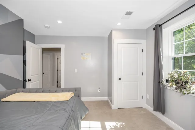 a spacious bedroom with a bed and a window