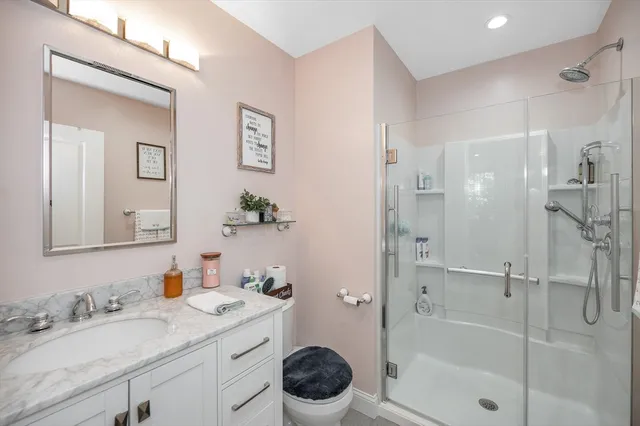 a bathroom with a granite countertop sink toilet and shower