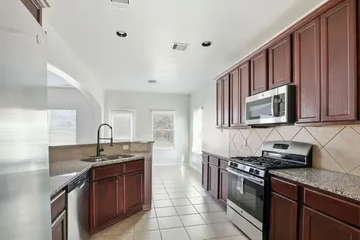 a kitchen with stainless steel appliances granite countertop a sink stove and cabinets