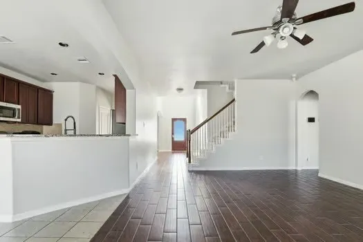 a view of a livingroom with wooden floor and a ceiling fan