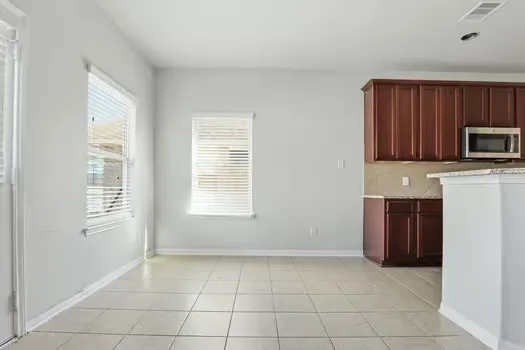 a kitchen with stainless steel appliances granite countertop a stove a sink a refrigerator and a microwave