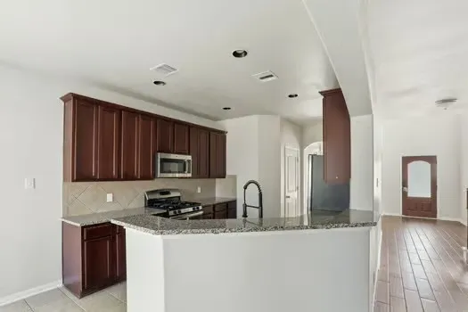 a kitchen with granite countertop a sink stainless steel appliances and cabinets