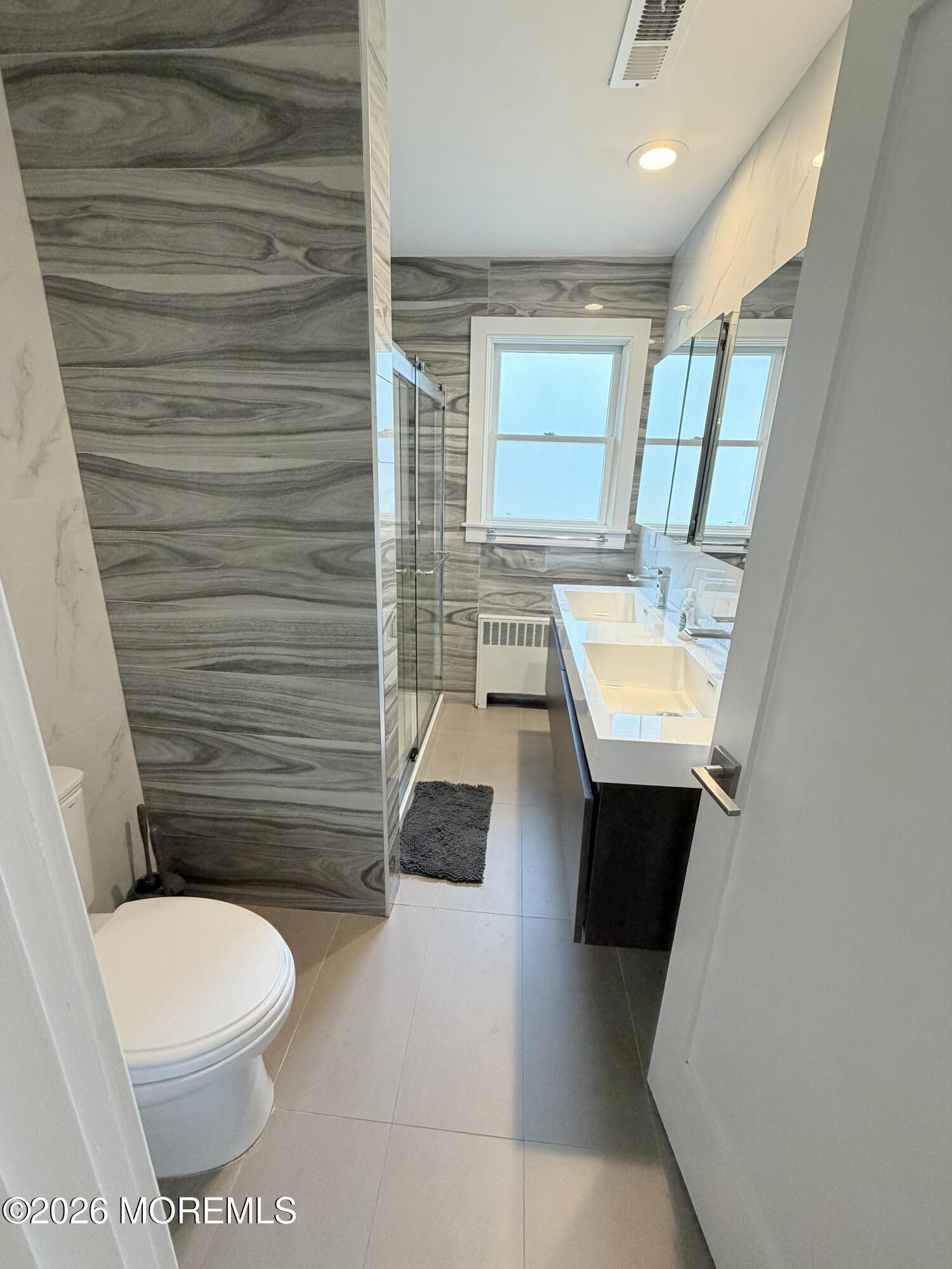 2025 Lesser Parkway Oakhurst, NJ 07755 - Photo 5 of 12 a bathroom with a toilet a sink a mirror and bathtub