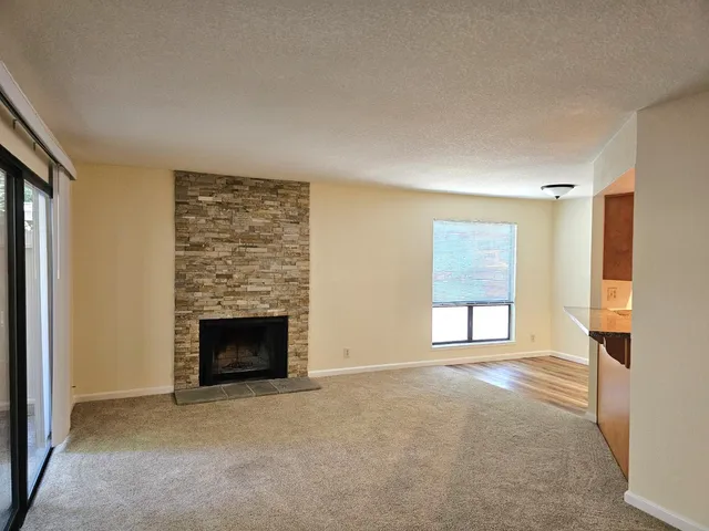 an empty room with windows and fireplace