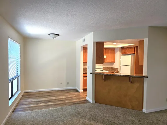 an empty room with large window and wooden floor