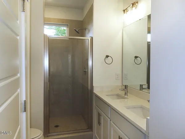 a bathroom with a shower sink and mirror