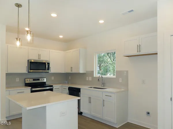 a kitchen with a sink a stove and cabinets