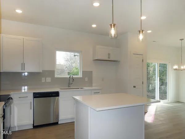 a kitchen with a sink a window and stainless steel appliances