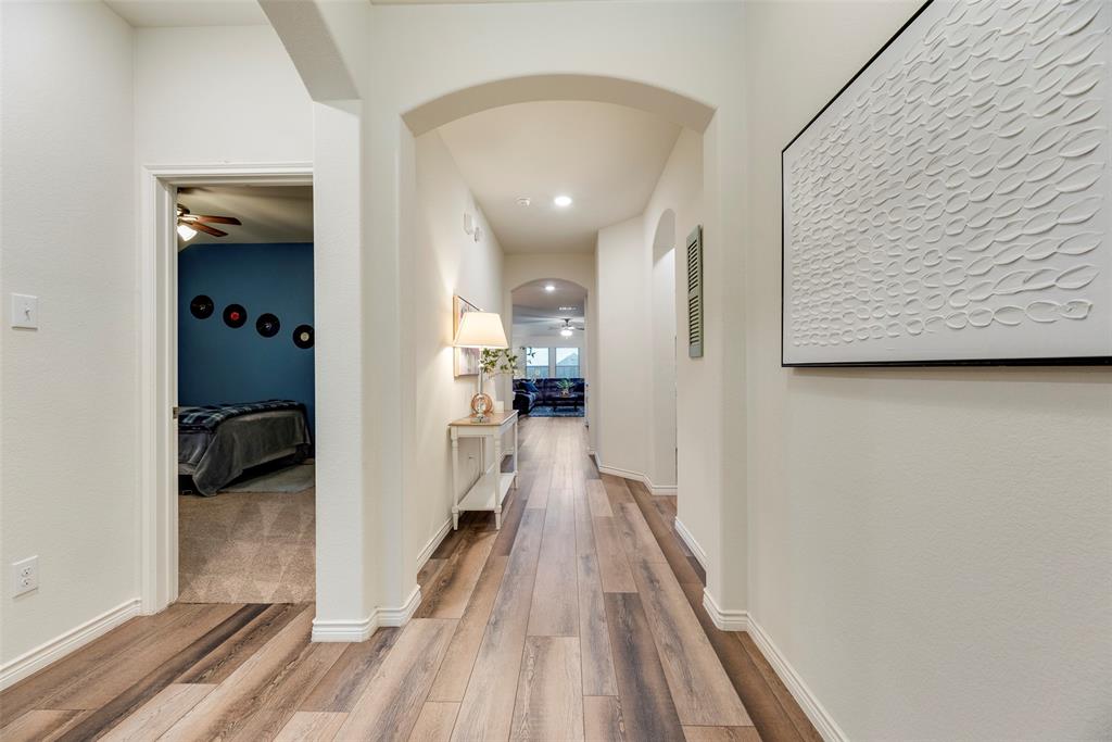3404 Rio Grande Road Little Elm, TX 75068 - Photo 11 of 39 Step inside to a welcoming entry with soaring ceilings, warm LVP flooring, and an elegant arched hallway that leads you into the heart of the home.