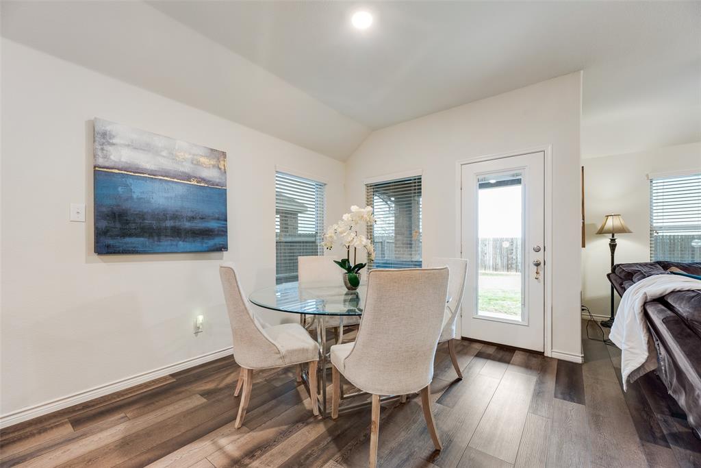 3404 Rio Grande Road Little Elm, TX 75068 - Photo 15 of 39 Bright dining area featuring large windows, beautiful flooring, and easy access to the backyard—perfect for everyday meals or entertaining guests.