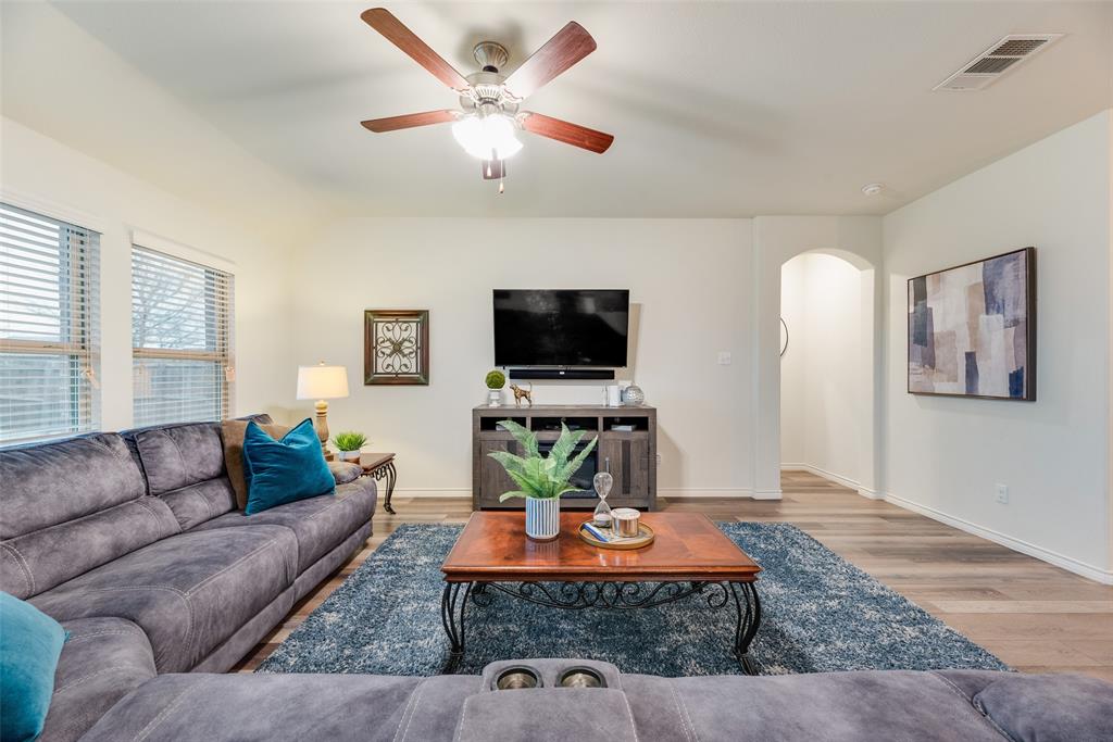 3404 Rio Grande Road Little Elm, TX 75068 - Photo 17 of 39 Spacious living room featuring an open-concept layout, ceiling fan, and seamless flow into the kitchen and dining areas—perfect for relaxing or entertaining.