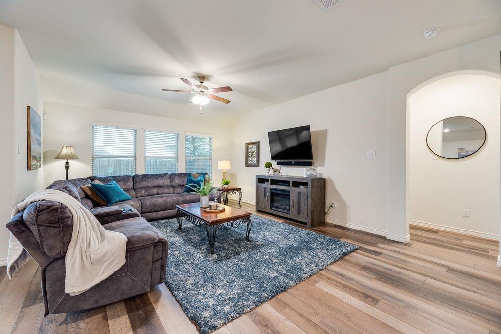 3404 Rio Grande Road Little Elm, TX 75068 - Photo 18 of 39 Light-filled living room featuring large windows, beautiful flooring, and an open layout that creates a bright and inviting space for relaxing or entertaining.