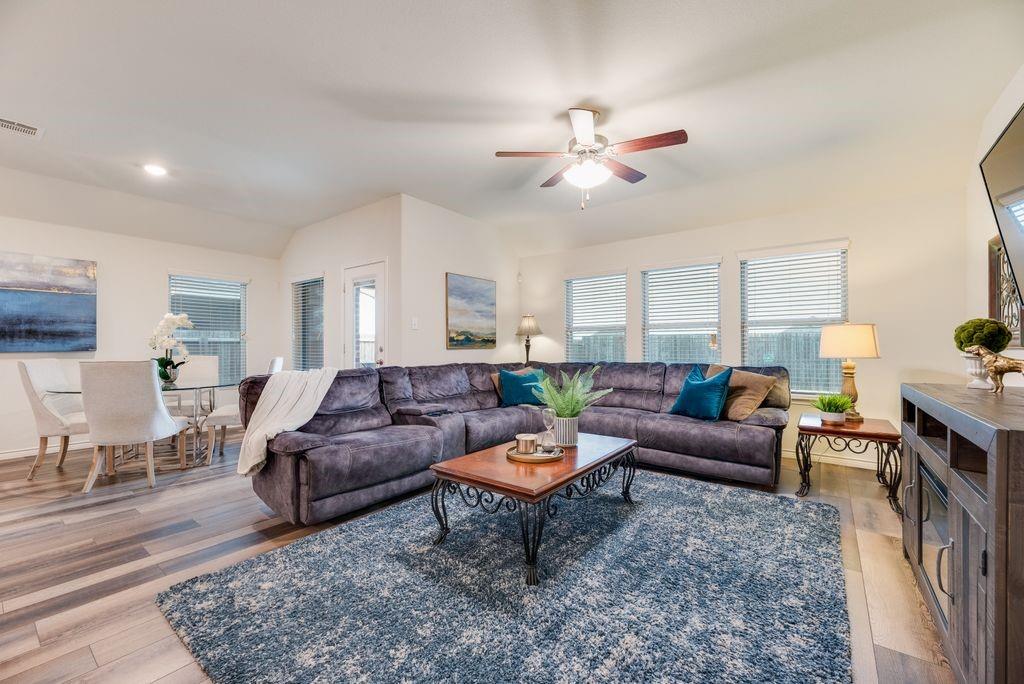 3404 Rio Grande Road Little Elm, TX 75068 - Photo 19 of 39 Bright and spacious living area featuring large windows for abundant natural light and an open layout connecting seamlessly to the dining space and kitchen.