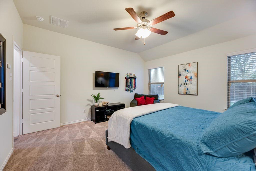 3404 Rio Grande Road Little Elm, TX 75068 - Photo 22 of 39 Comfortable primary bedroom featuring large windows for natural light, plush carpeting, and a spacious layout for relaxing at the end of the day.