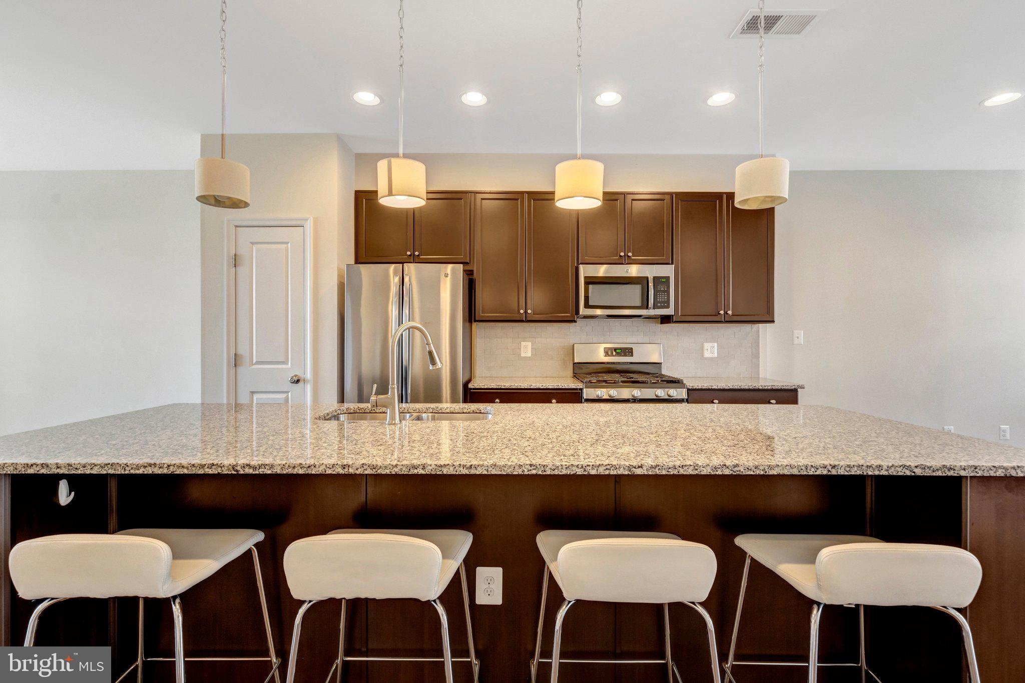 8932 Dahlgren Ridge Road Manassas, VA 20111 - Photo 11 of 41 a kitchen with stainless steel appliances granite countertop a table chairs sink and refrigerator