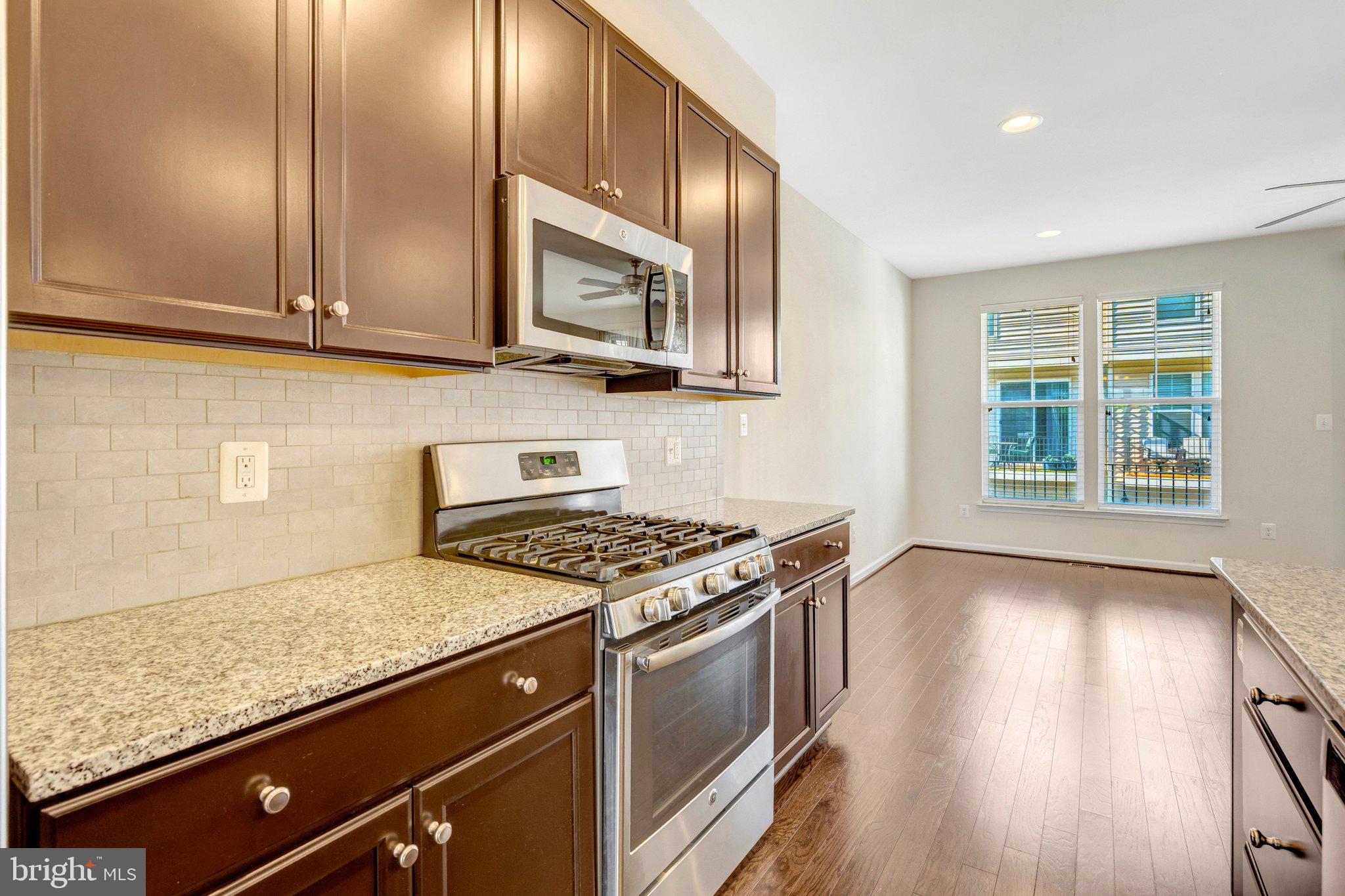8932 Dahlgren Ridge Road Manassas, VA 20111 - Photo 13 of 41 a kitchen with stainless steel appliances granite countertop wooden cabinets and a stove top oven