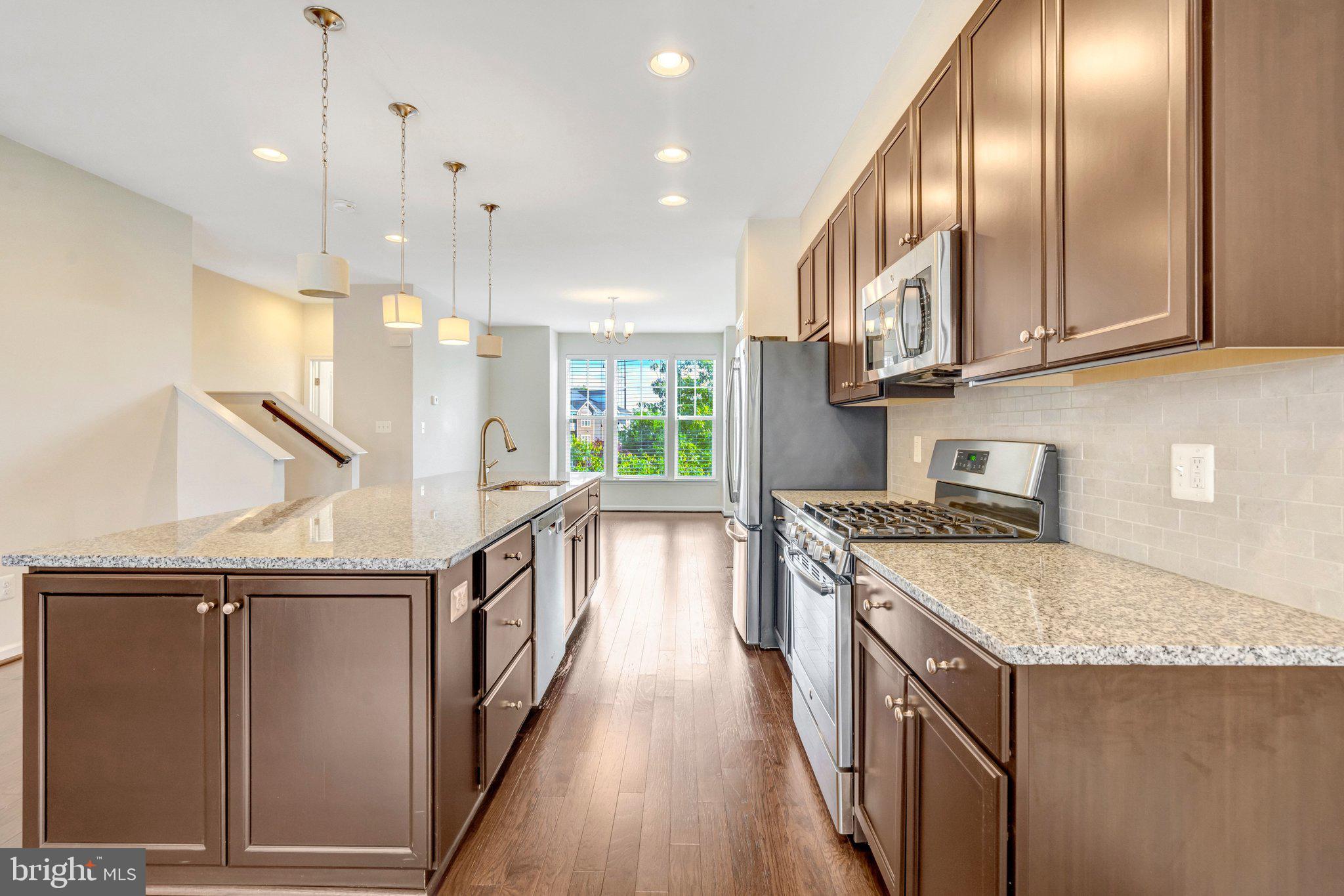 8932 Dahlgren Ridge Road Manassas, VA 20111 - Photo 14 of 41 a kitchen with stainless steel appliances granite countertop a stove a sink and a refrigerator