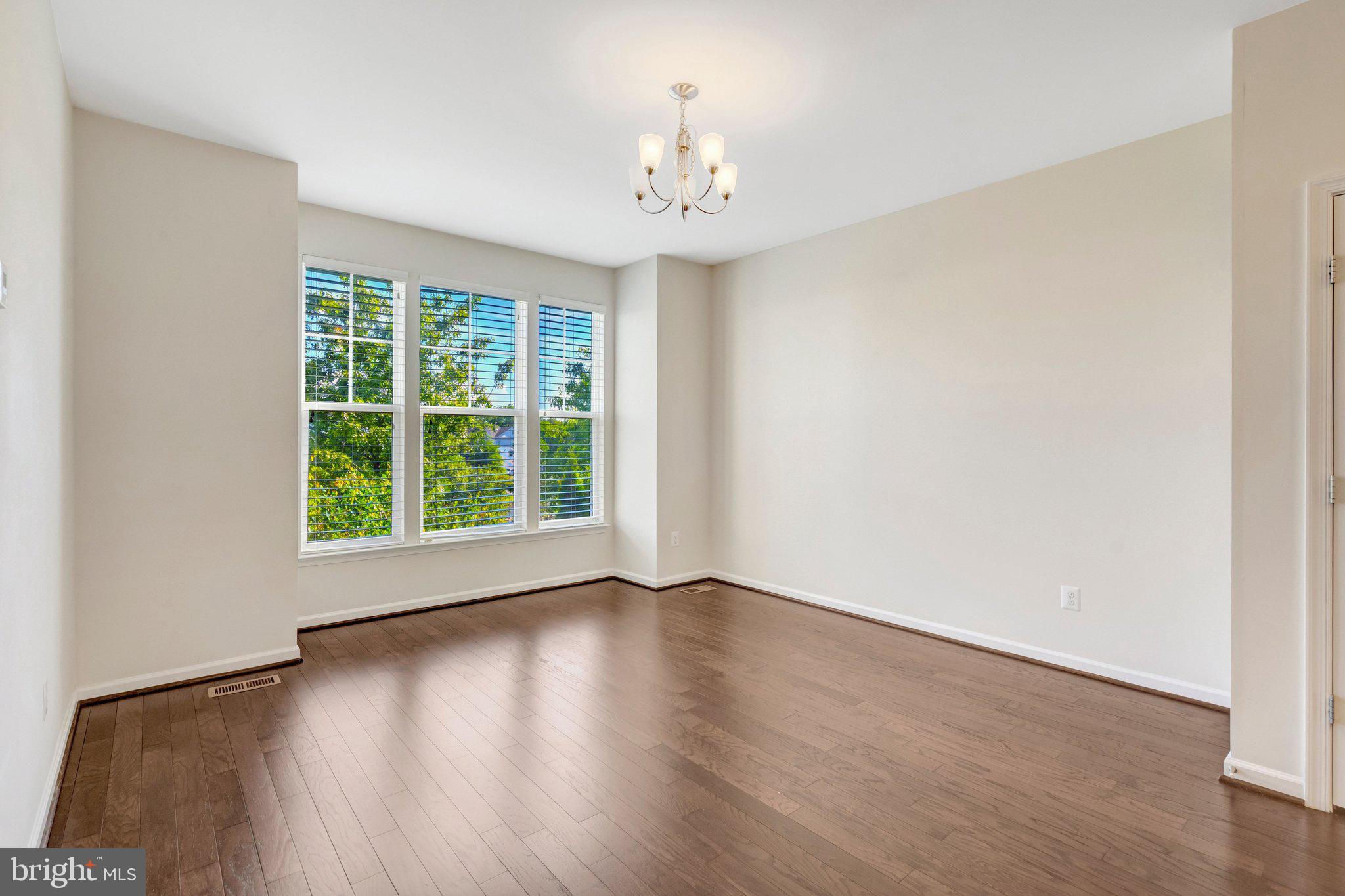8932 Dahlgren Ridge Road Manassas, VA 20111 - Photo 15 of 41 a view of an empty room with wooden floor and a window